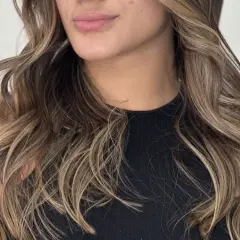 Cabello castaño con mechas babylight sutiles, creando un efecto natural y luminoso.