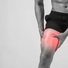Hombre sujetando su muslo con dolor intenso, indicando agujetas muy dolorosas tras el ejercicio.