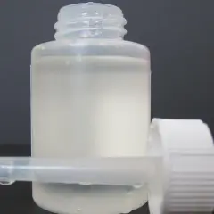 Frasco con gotero y líquido blanco lechoso, listo para usar como suero casero.