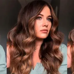 Mujer con ondulado pelo marrón caramelo, con reflejos dorados que iluminan su rostro.