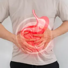 Hombre con dolor de estómago, buscando qué tomar para el reflujo. Imagen ilustra malestar digestivo.