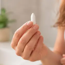 Mujer sosteniendo un supositorio. El ácido bórico para que sirve es para tratar infecciones vaginales.