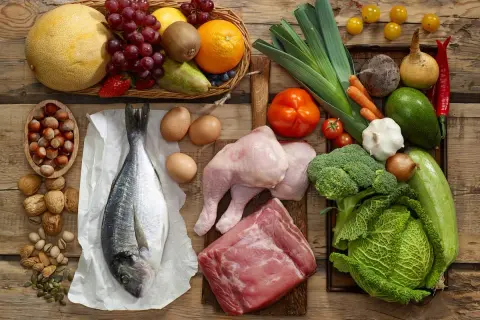 Variedad de alimentos con colágeno: pescado, pollo, carne, huevos, frutos secos y verduras.