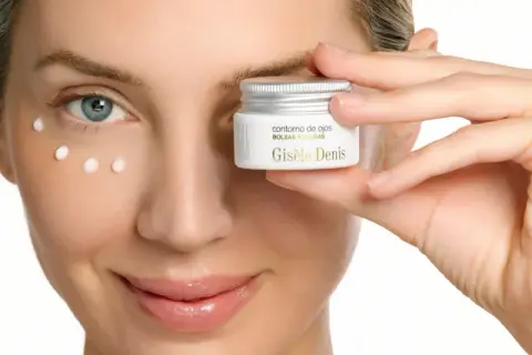 Descubre para qué sirve el contorno de ojos: una mujer aplica puntos de crema Giséle Denis para combatir bolsas y ojeras.