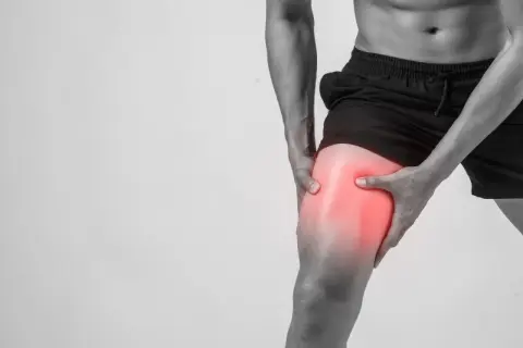 Hombre sujetando su muslo con dolor intenso, indicando agujetas muy dolorosas tras el ejercicio.