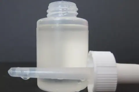 Frasco con gotero y líquido blanco lechoso, listo para usar como suero casero.