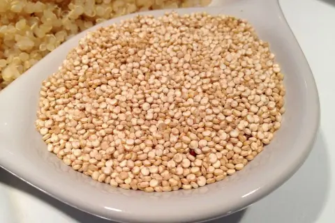 Un tazón de quinoa cruda, lista para cocinar y aprovechar sus increíbles propiedades nutricionales.