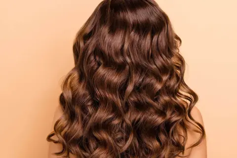 Cabello castaño ondulado y brillante, perfecto para aprender como peinar pelo rizado y lucir espectacular.