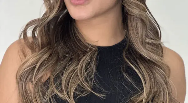 Cabello castaño con mechas babylight sutiles, creando un efecto natural y luminoso.