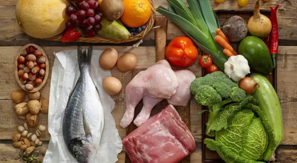 Variedad de alimentos con colágeno: pescado, pollo, carne, huevos, frutos secos y verduras.
