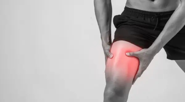 Hombre sujetando su muslo con dolor intenso, indicando agujetas muy dolorosas tras el ejercicio.