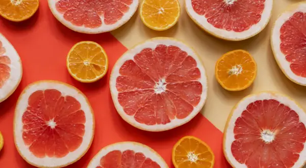 Pomelos y mandarinas cortados por la mitad, listos para disfrutar de los beneficios del pomelo en ayunas.