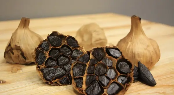 Ajo negro, con sus dientes oscuros y textura caramelizada, revela los grandes beneficios del ajo negro.