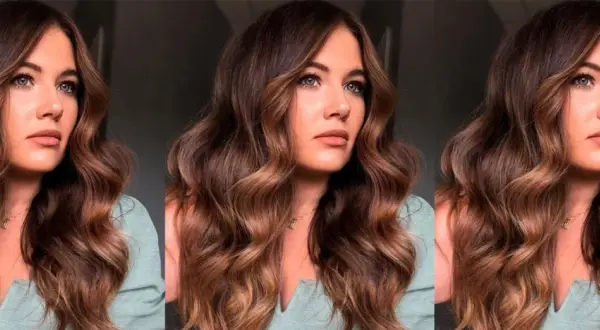 Mujer con ondulado pelo marrón caramelo, con reflejos dorados que iluminan su rostro.