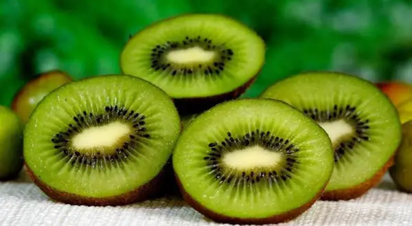 Kiwis cortados, mostrando su interior verde y semillas negras. Considerada la mejor fruta para adelgazar por su fibra y bajo contenido calórico.