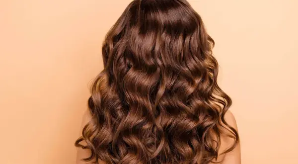 Cabello castaño ondulado y brillante, perfecto para aprender como peinar pelo rizado y lucir espectacular.