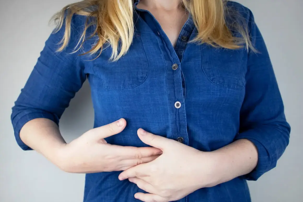Persona con las manos en el abdomen, sintiendo pinchazos en el costado derecho debajo de las costillas.