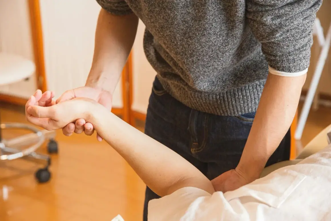 Terapeuta examina la muñeca de un paciente. ¿Puedo ir a trabajar con un esguince de muñeca?
