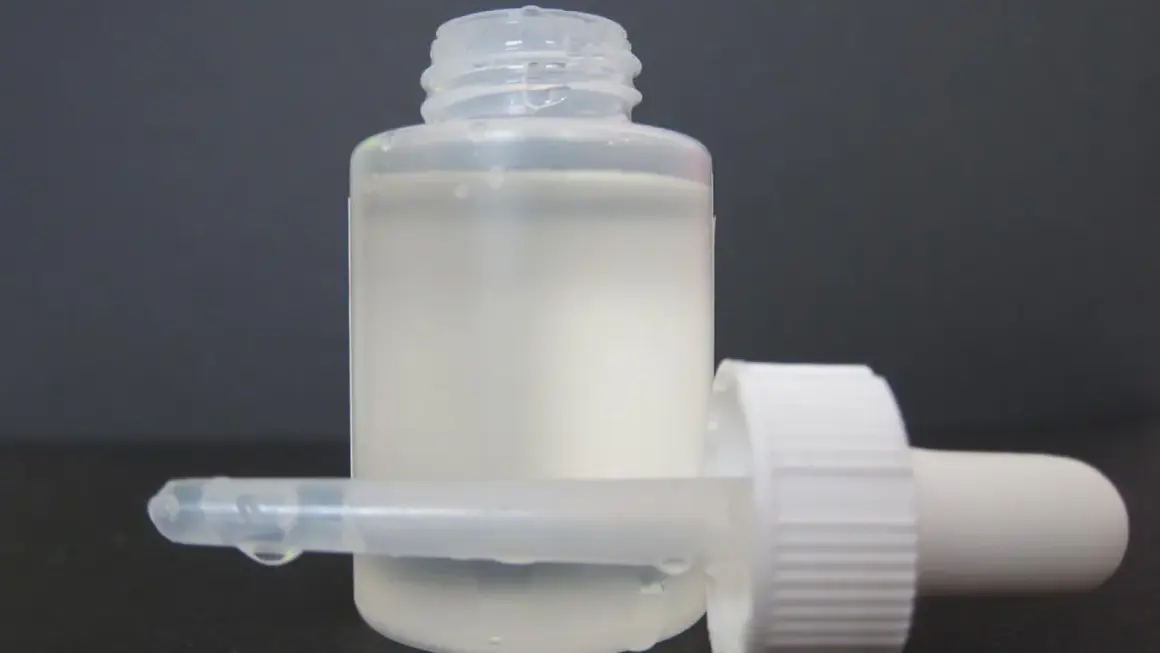 Frasco con gotero y líquido blanco lechoso, listo para usar como suero casero.