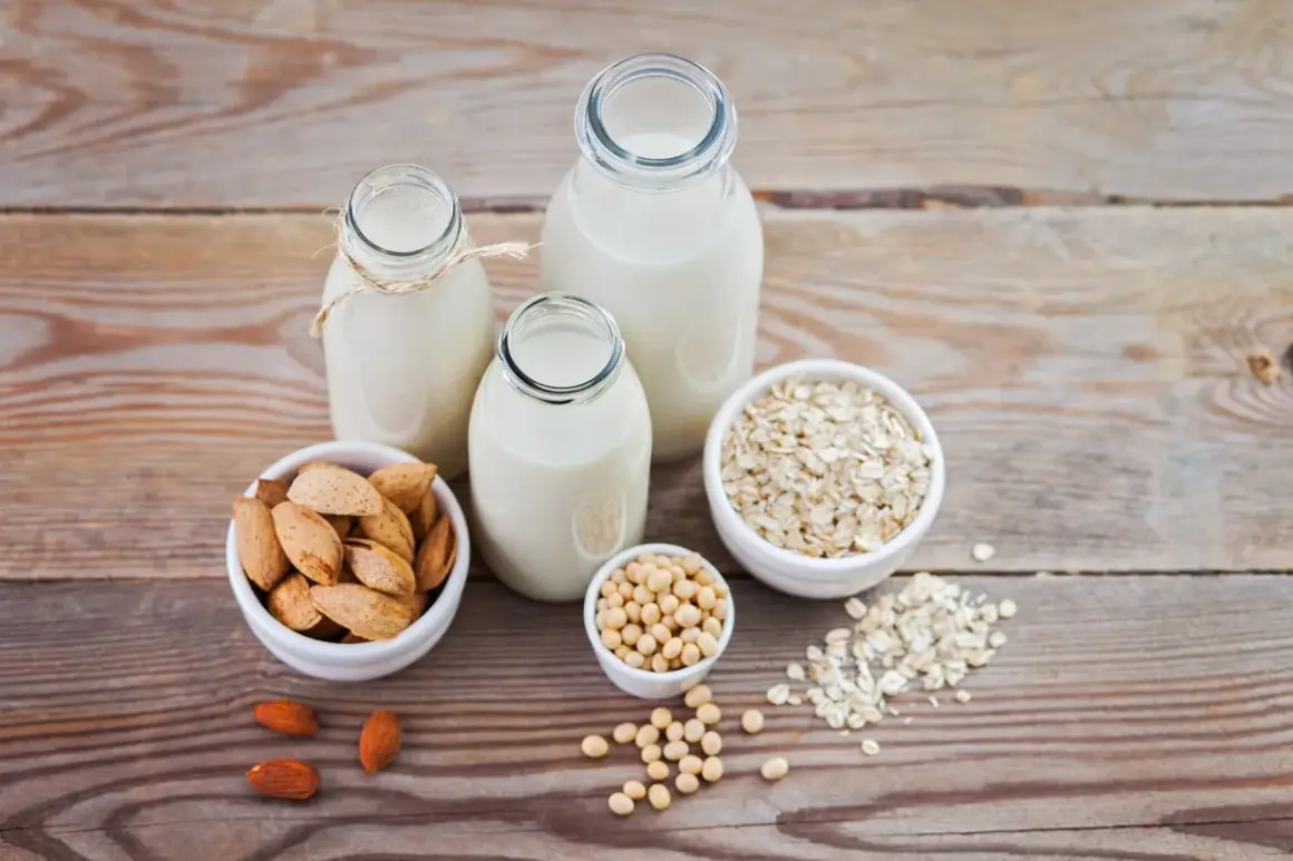 Tres botellas con diferentes tipos de leches vegetales: almendra, soja y avena, junto a sus ingredientes.