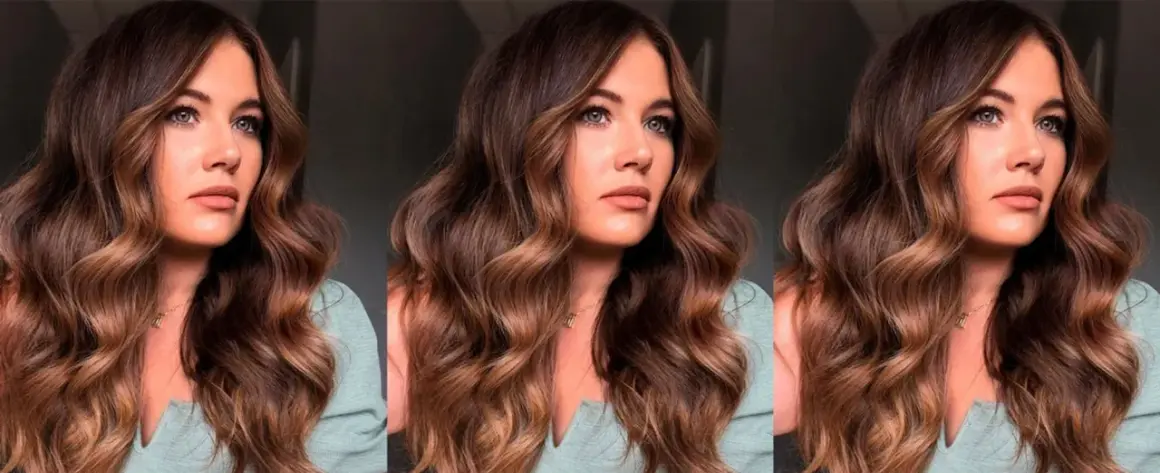 Mujer con ondulado pelo marrón caramelo, con reflejos dorados que iluminan su rostro.
