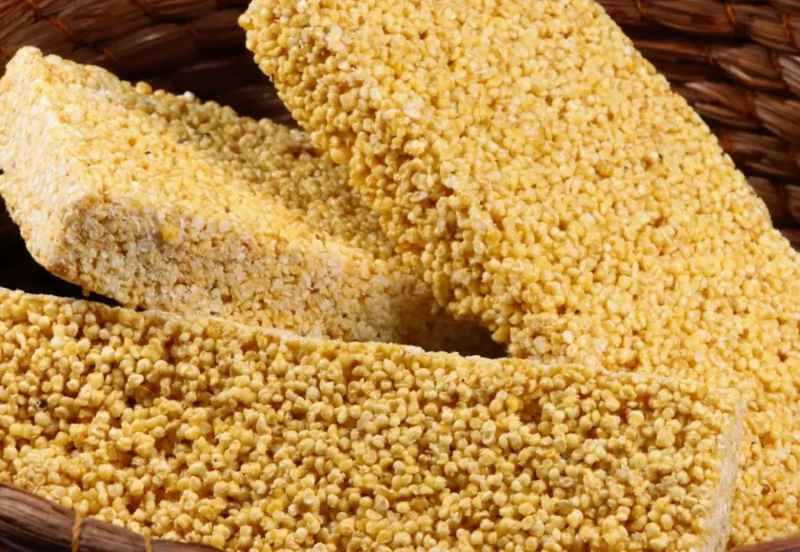 Barras de amaranto que es un cereal nutritivo, crujientes y doradas, apiladas en una cesta de mimbre.
