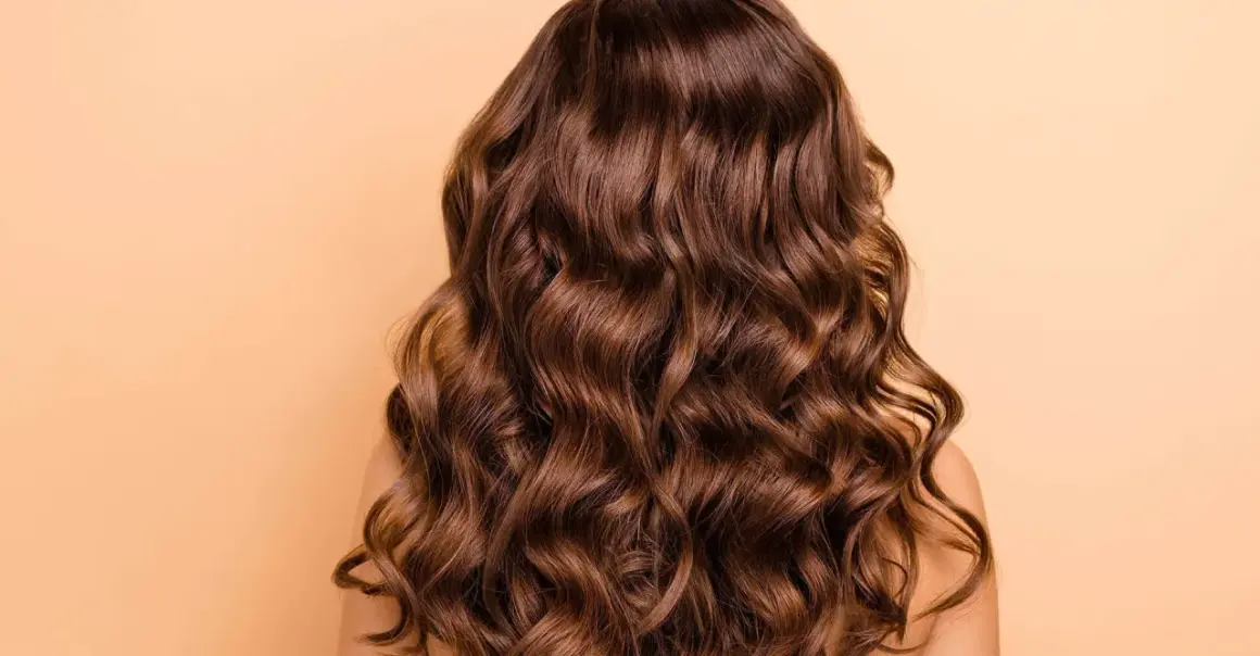 Cabello castaño ondulado y brillante, perfecto para aprender como peinar pelo rizado y lucir espectacular.
