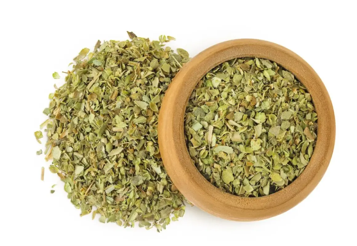 Hierbas secas de mejorana en un cuenco de madera y esparcidas. Descubre las mejorana propiedades para tu cocina y bienestar.
