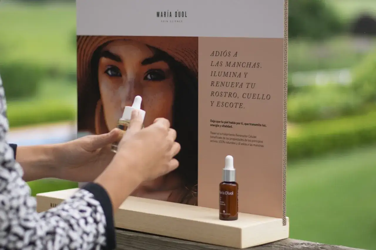 Manos sostienen un frasco de vitamina C, ideal para combatir manchas solares y renovar la piel.