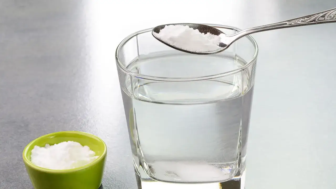 Cuchara con bicarbonato lista para a&ntilde;adir a un vaso de agua. Descubre los agua con bicarbonato beneficios para tu salud.