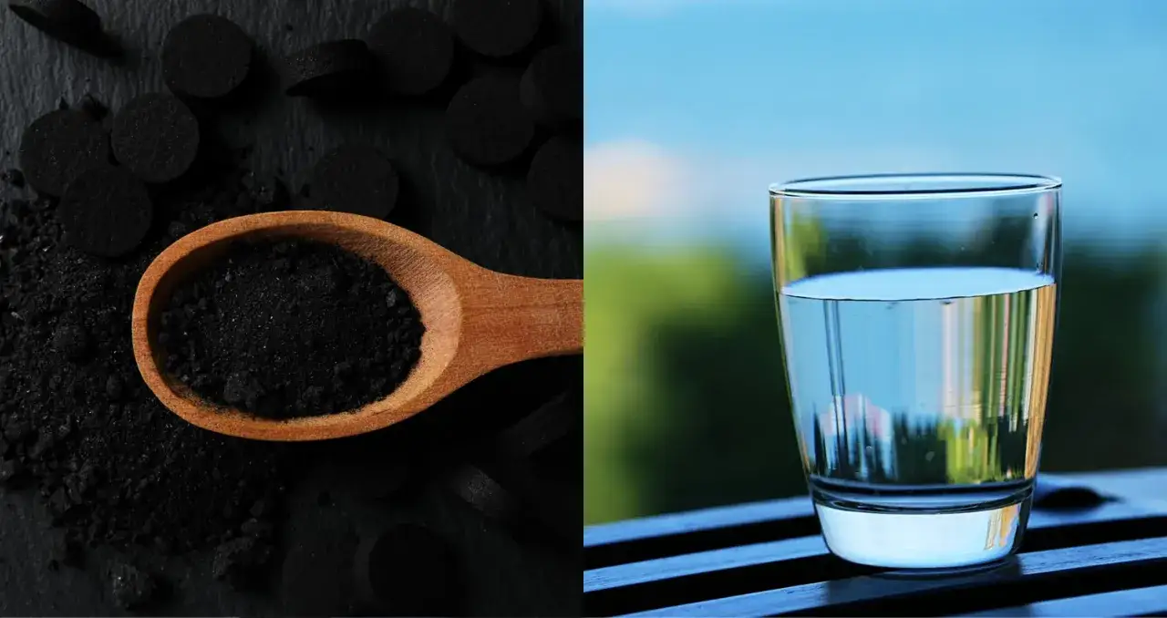 Carbón vegetal activado en cuchara de madera y un vaso de agua cristalina.
