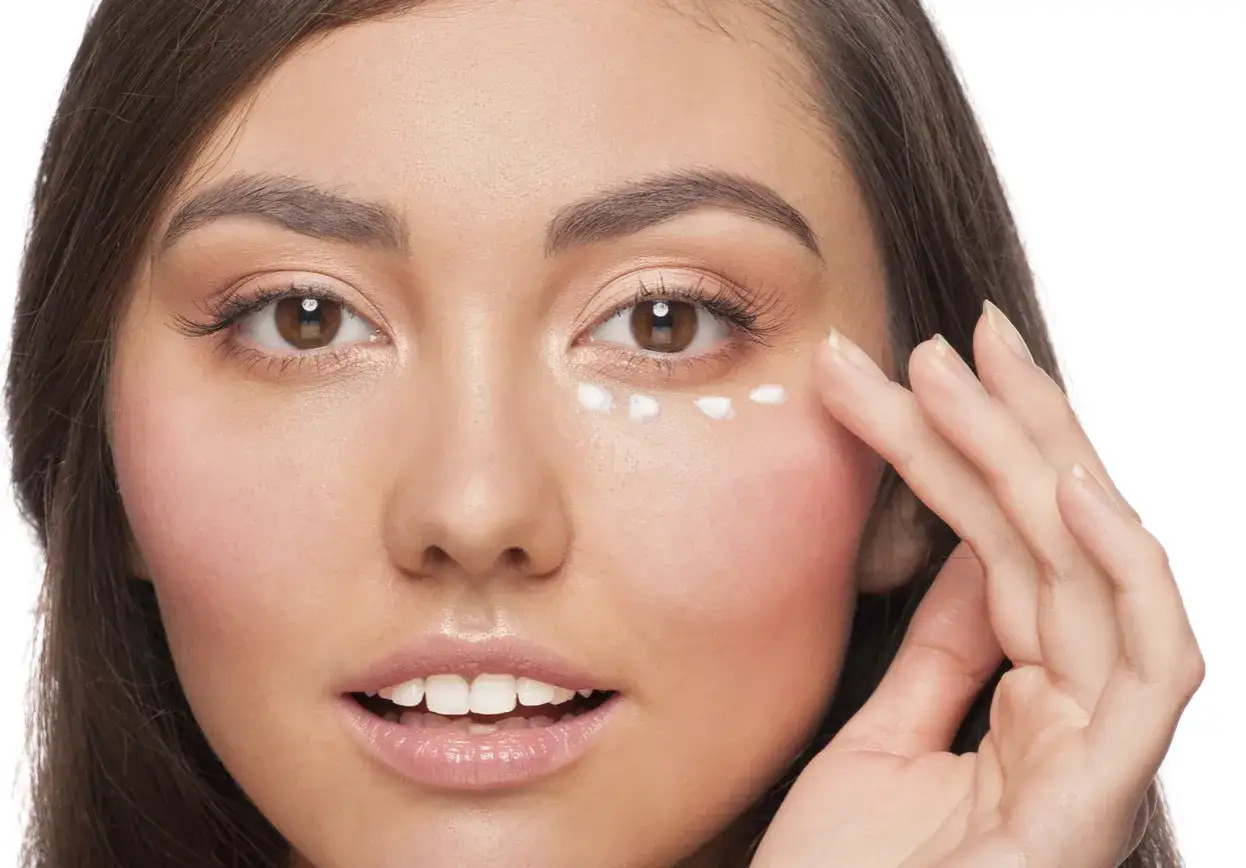 Una mujer se aplica crema en el contorno de ojos. Descubre para qu&eacute; sirve el contorno de ojos y c&oacute;mo puede mejorar tu piel.