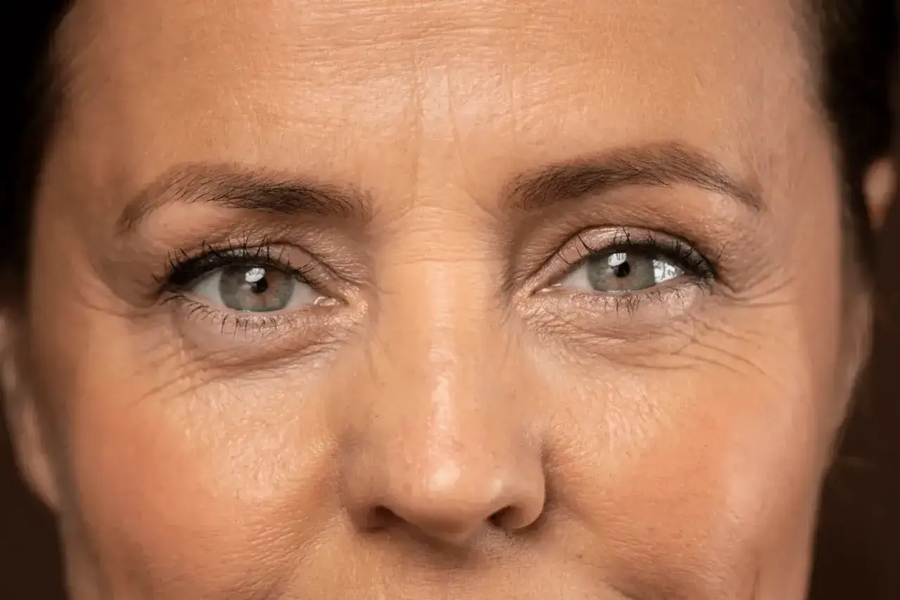 Primer plano de unos ojos con l&iacute;neas bajo los ojos, que cuentan historias de risas y experiencias vividas.