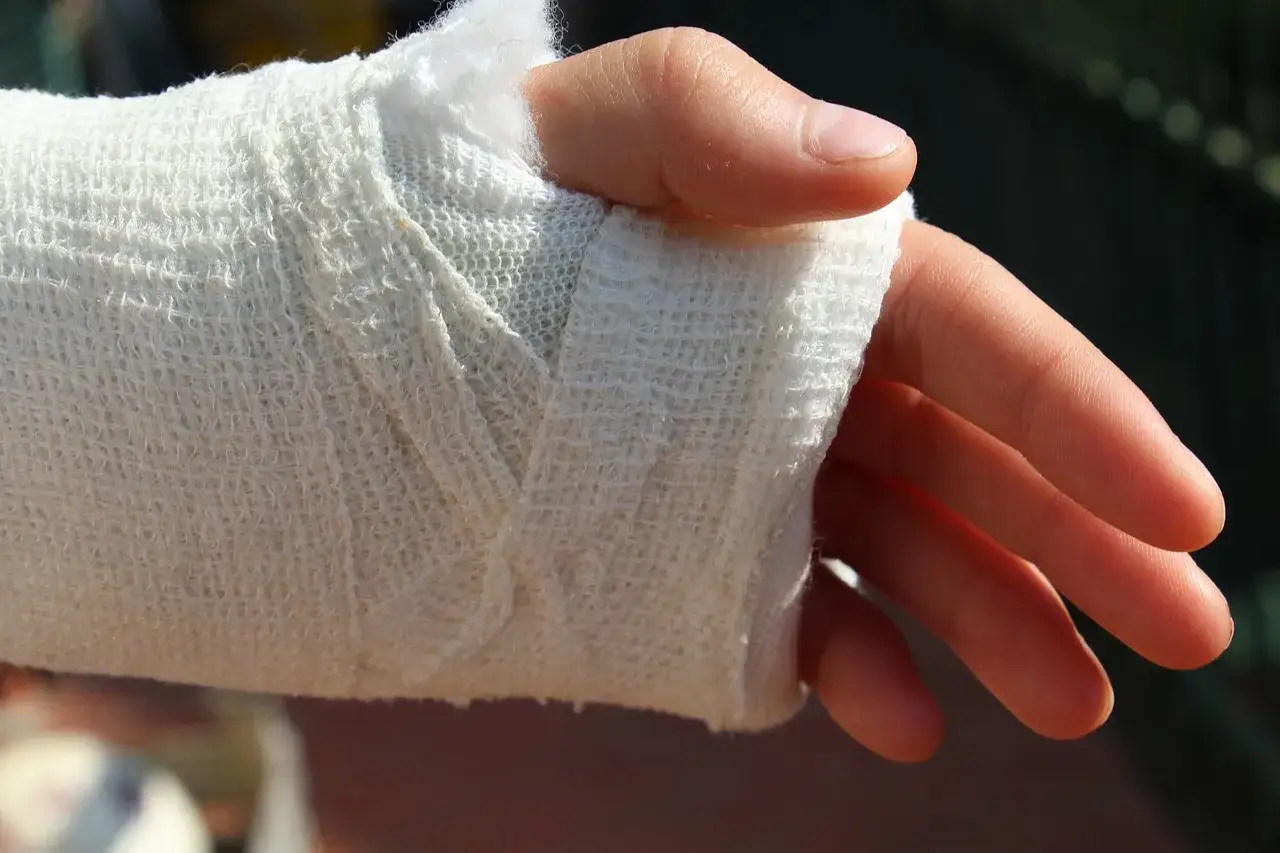 Mano con esguince de mu&ntilde;eca vendada. A pesar de la lesi&oacute;n, la persona se pregunta si puedo ir a trabajar.