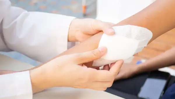 Manos curando una herida infectada con pus. Aprende cómo curar una herida infectada con pus para una pronta recuperación.