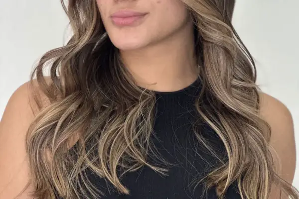 Cabello castaño con mechas babylight sutiles, creando un efecto natural y luminoso.