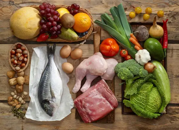 Variedad de alimentos con colágeno: pescado, pollo, carne, huevos, frutos secos y verduras.