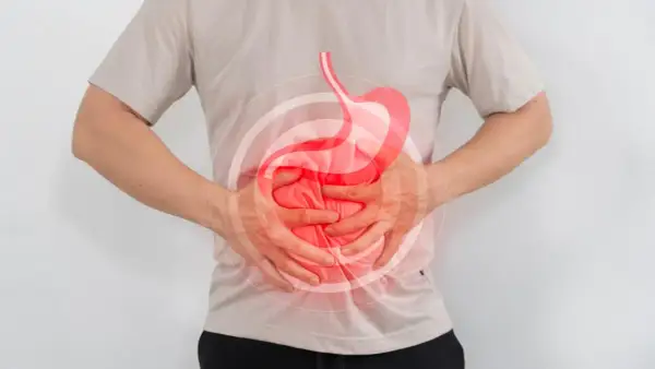Hombre con dolor de estómago, buscando qué tomar para el reflujo. Imagen ilustra malestar digestivo.