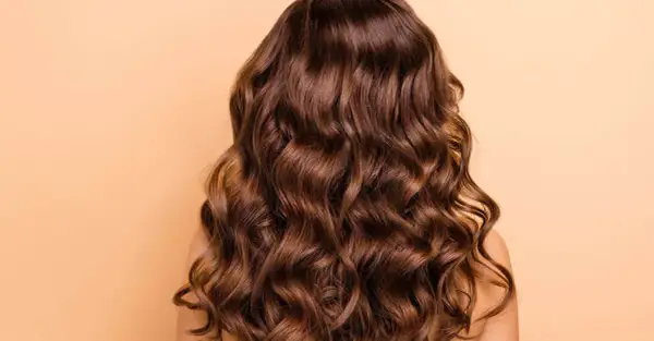 Cabello castaño ondulado y brillante, perfecto para aprender como peinar pelo rizado y lucir espectacular.